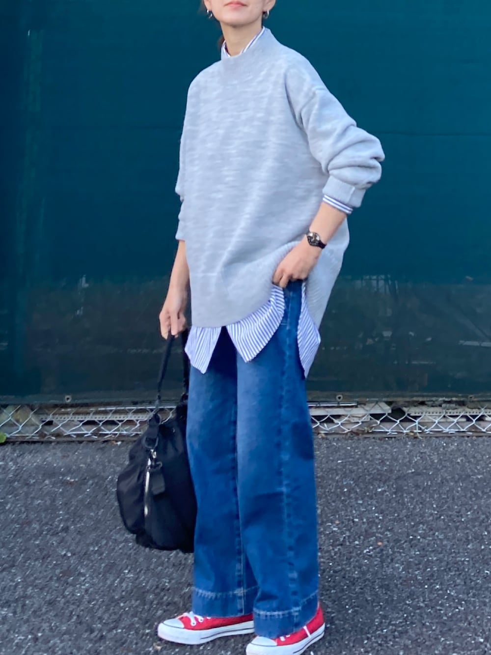 ブラック系のダウンベスト、グレー系のニット/セーター、ブルー系のシャツ/ブラウスを着用したレディースの冬コーディネートの2枚目の写真