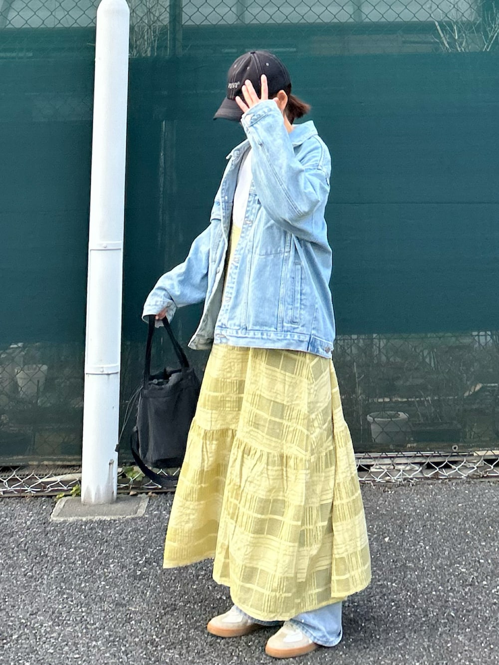 ブルー系のデニムジャケット、グリーン系のワンピース、ブルー系のデニムパンツを着用したレディースの春コーディネートの2枚目の写真