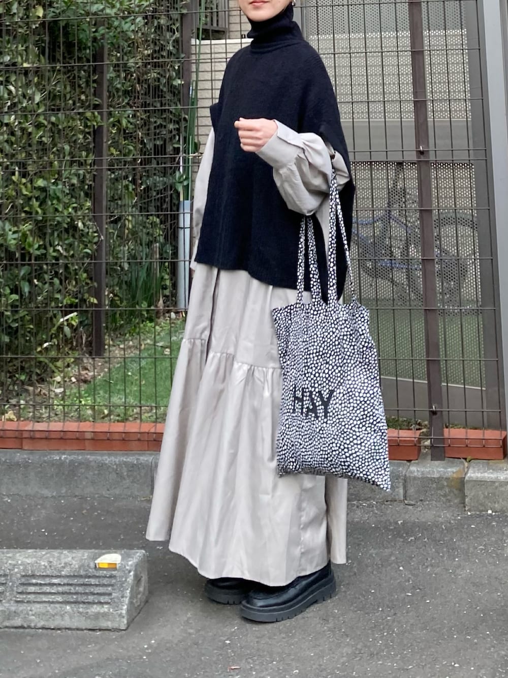 ブラック系のニット/セーター、ベージュ系のシャツワンピース、ブラック系のトートバッグを着用したレディースの冬コーディネートの2枚目の写真