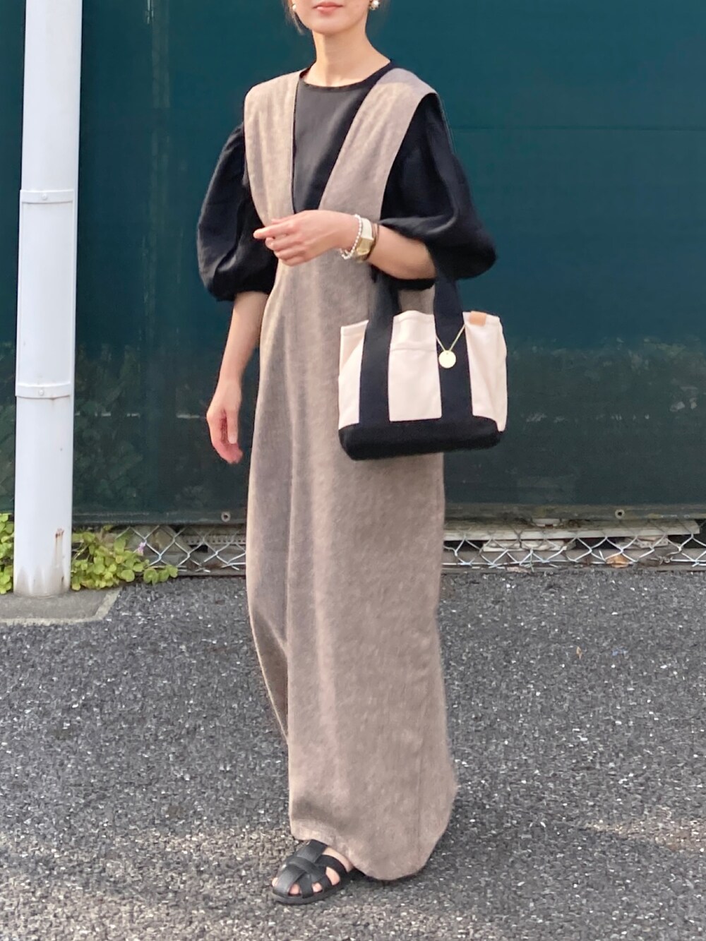 ブラック系のシャツ/ブラウス、ブラウン系のジャンパースカート、ホワイト系のトートバッグを着用したレディースの夏コーディネートの2枚目の写真