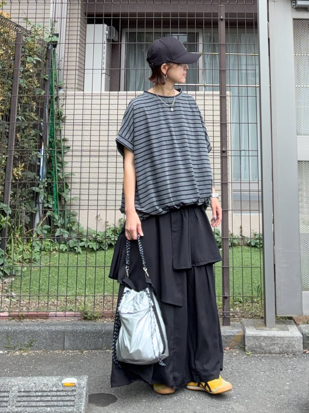 グレー系のTシャツ/カットソー、ブラック系のスカート、シルバー系のショルダーバッグを着用したレディースの夏コーディネートの3枚目の写真