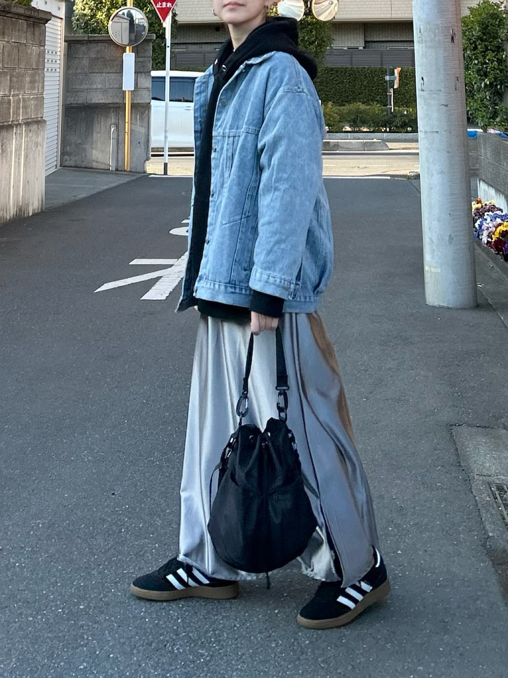 ブルー系のデニムジャケット、シルバー系のスカート、ブラック系のショルダーバッグを着用したレディースの春コーディネートの3枚目の写真