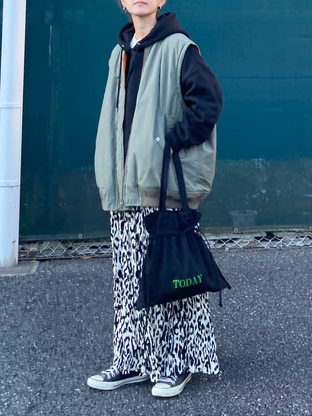 ブラック系のパーカー、ベージュ系のスカート、ブラック系のトートバッグを着用したレディースの秋コーディネートの2枚目の写真