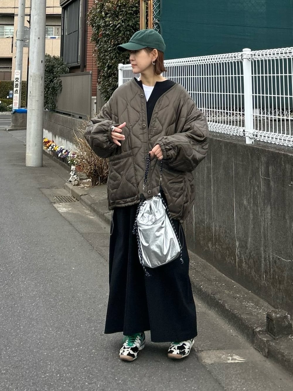 ブラウン系のブルゾン、シルバー系のトートバッグ、ブラック系のスニーカーを着用したレディースの冬コーディネートの2枚目の写真