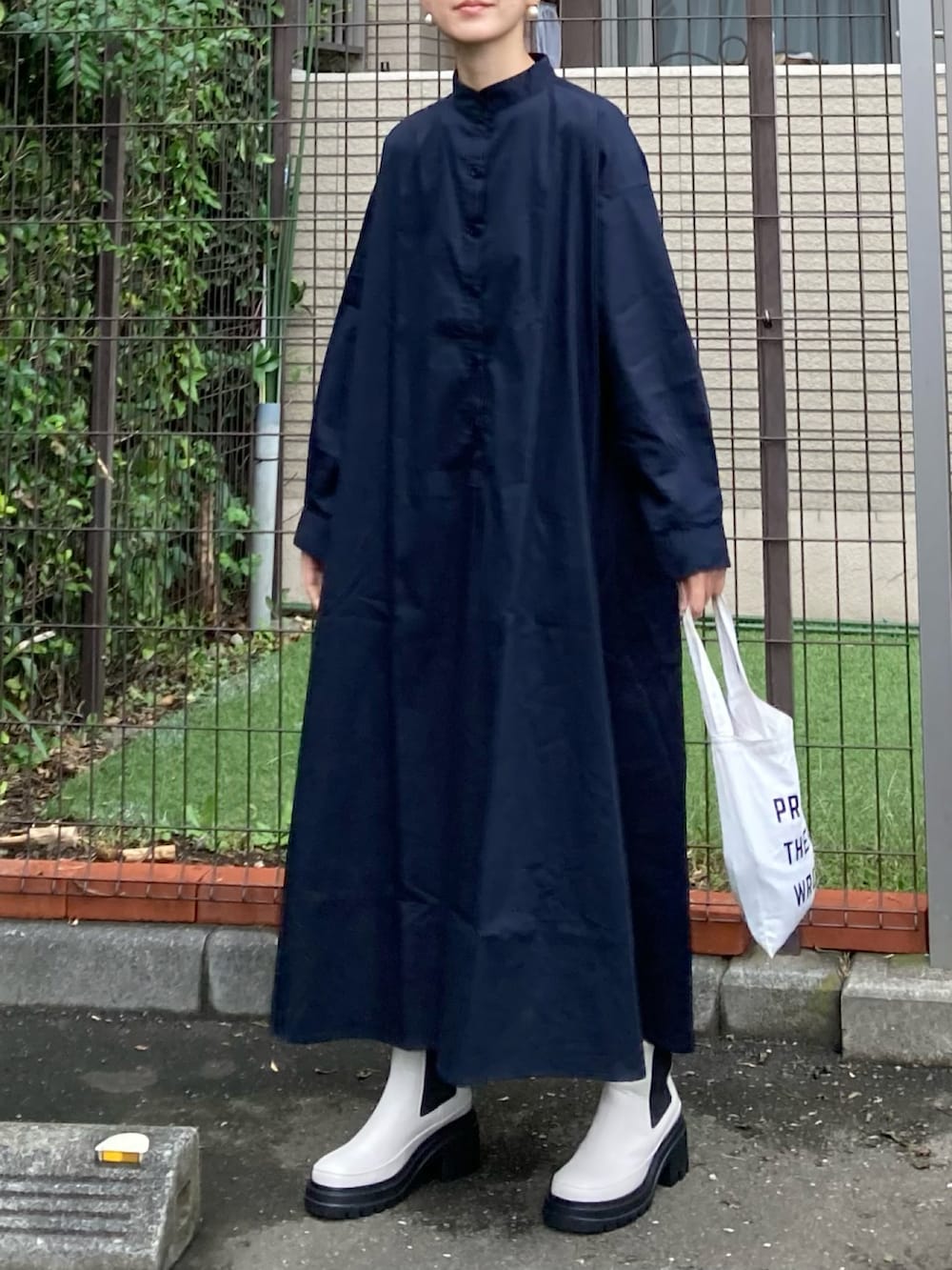 ブルー系のシャツワンピース、ホワイト系のブーツ、ゴールド系のピアス（両耳用）を着用したレディースの秋コーディネートの2枚目の写真