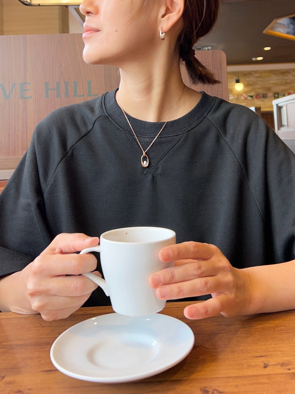 ブラック系のワンピース、オレンジ系のトートバッグ、シルバー系のスニーカーを着用したレディースの秋コーディネートの3枚目の写真