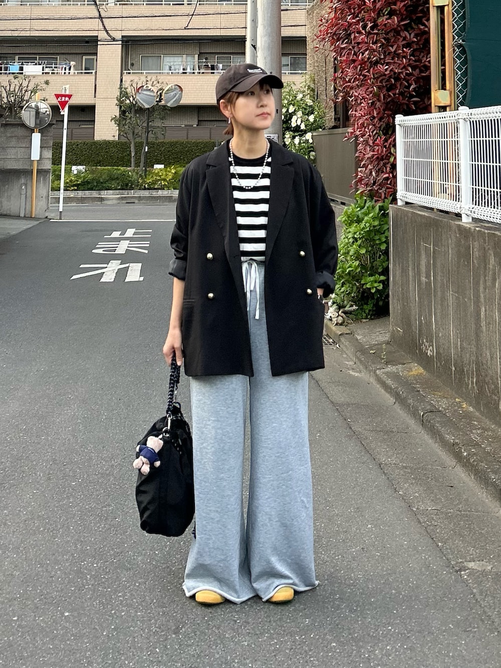 ブラック系のTシャツ/カットソー、ブラック系のテーラードジャケット、ブラック系のトートバッグを着用したレディースの春コーディネートの5枚目の写真