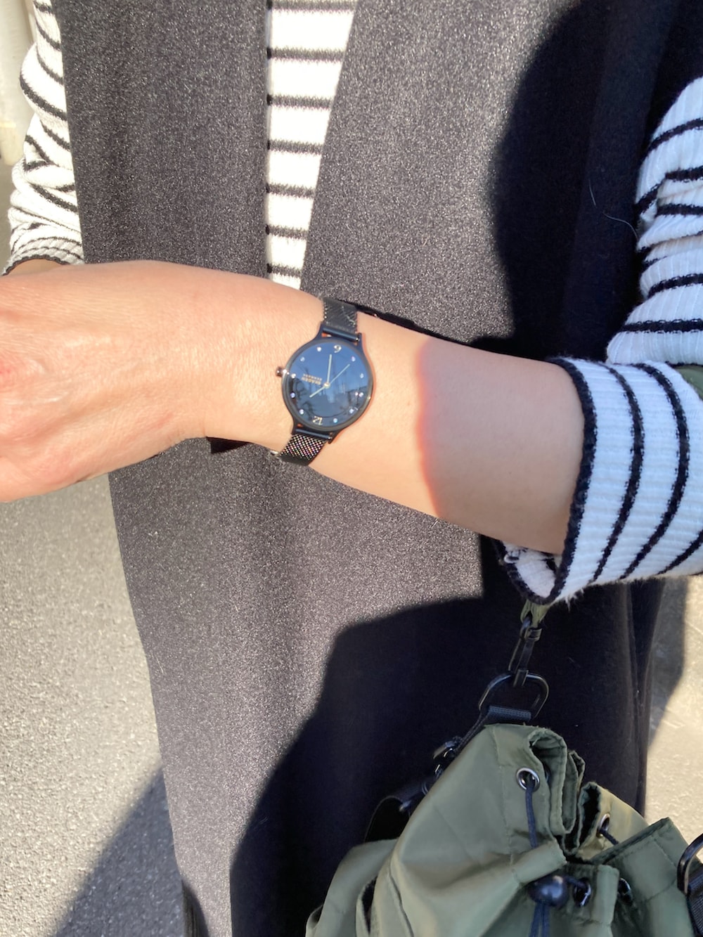 ホワイト系のニット/セーター、ブラック系のワンピース、グリーン系のショルダーバッグを着用したレディースの冬コーディネートの3枚目の写真