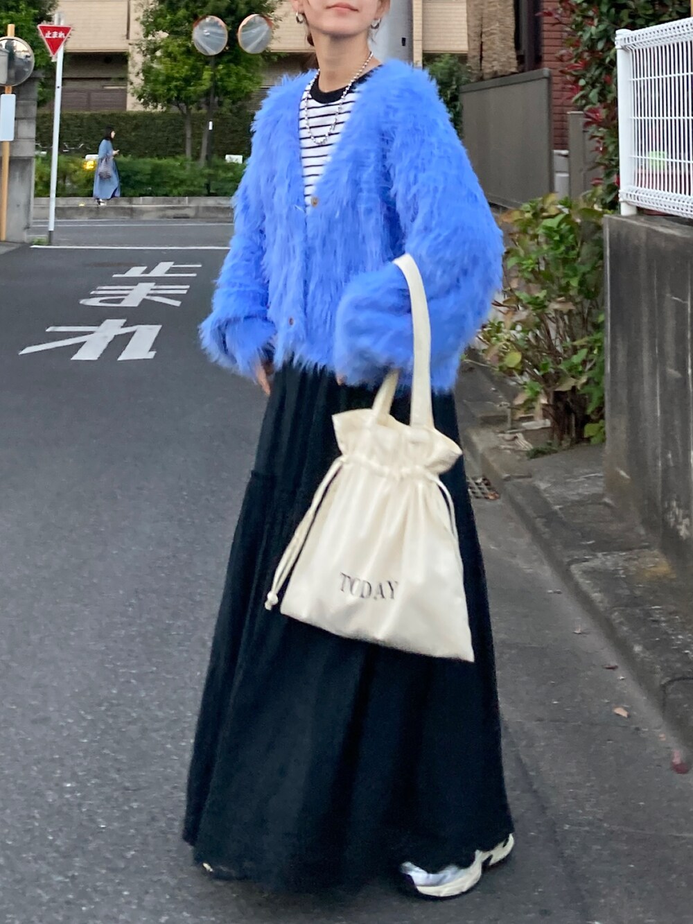 ブルー系のニット/セーター、ブラック系のTシャツ/カットソー、ブラック系のスカートを着用したレディースの秋コーディネートの4枚目の写真