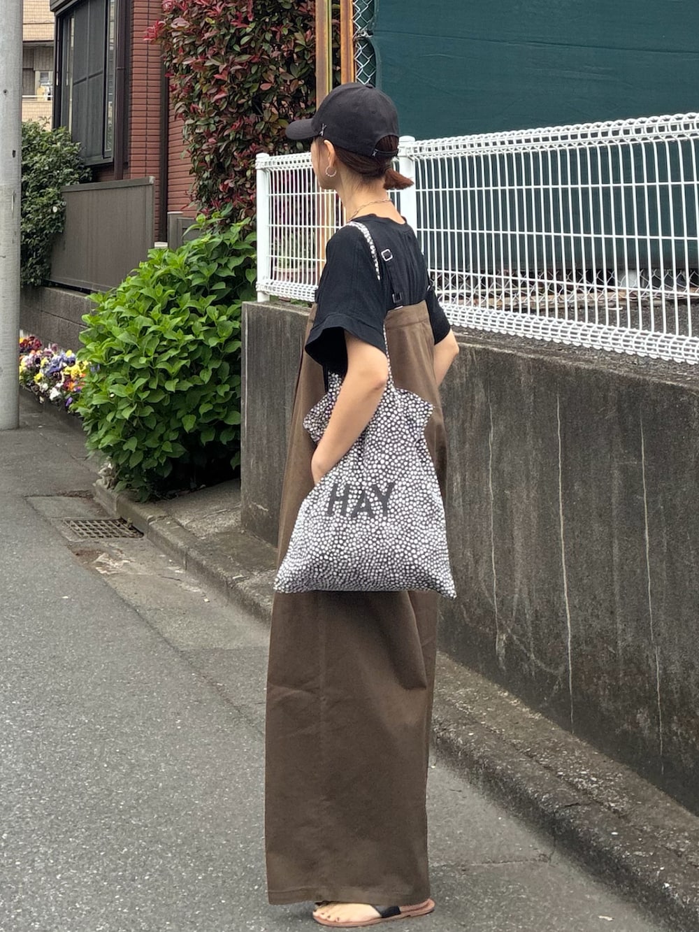 ブラック系のTシャツ/カットソー、ブラウン系のサロペット/オーバーオール、ブラック系のキャップを着用したレディースの春コーディネートの5枚目の写真