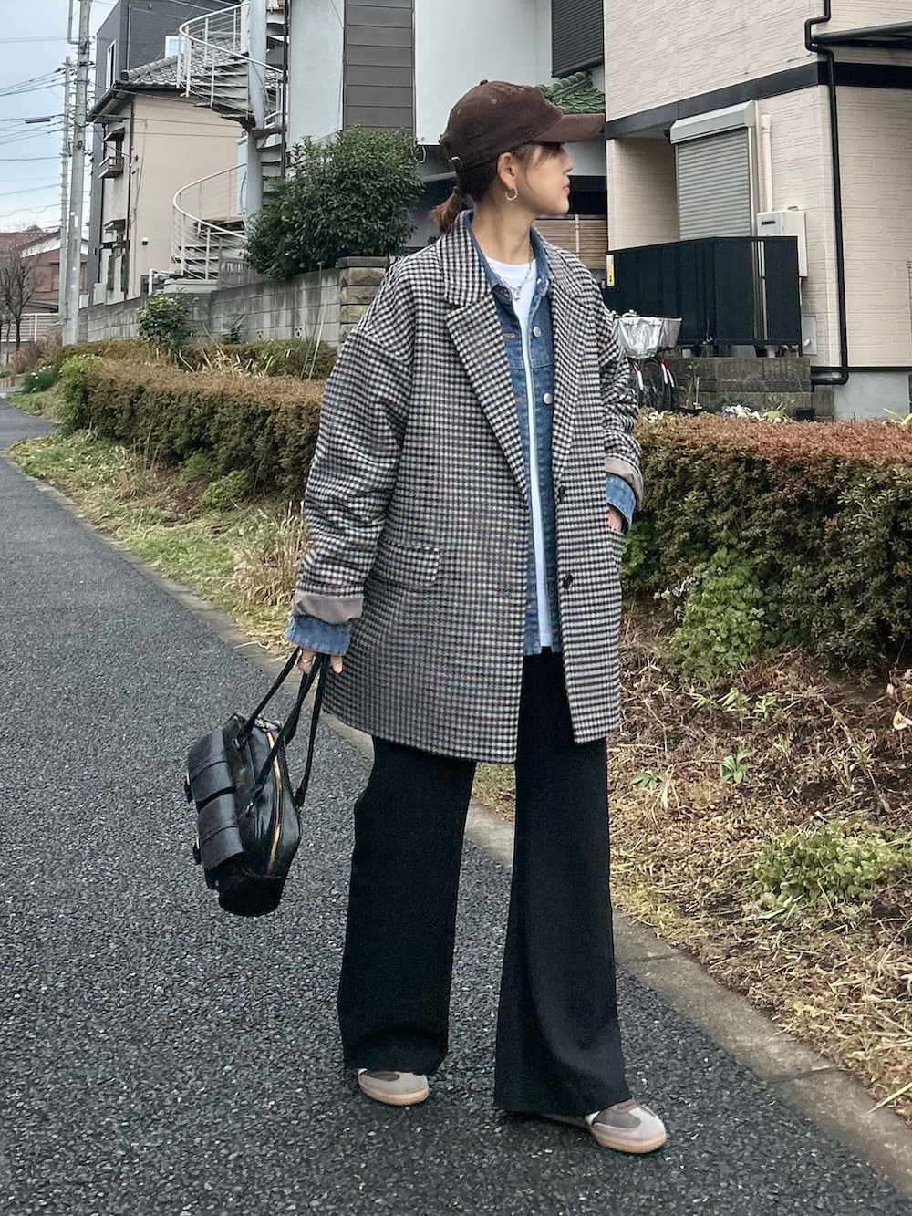 ホワイト系のTシャツ/カットソー、ブラック系のスラックス、ブラック系のハンドバッグを着用したレディースの冬コーディネートの2枚目の写真