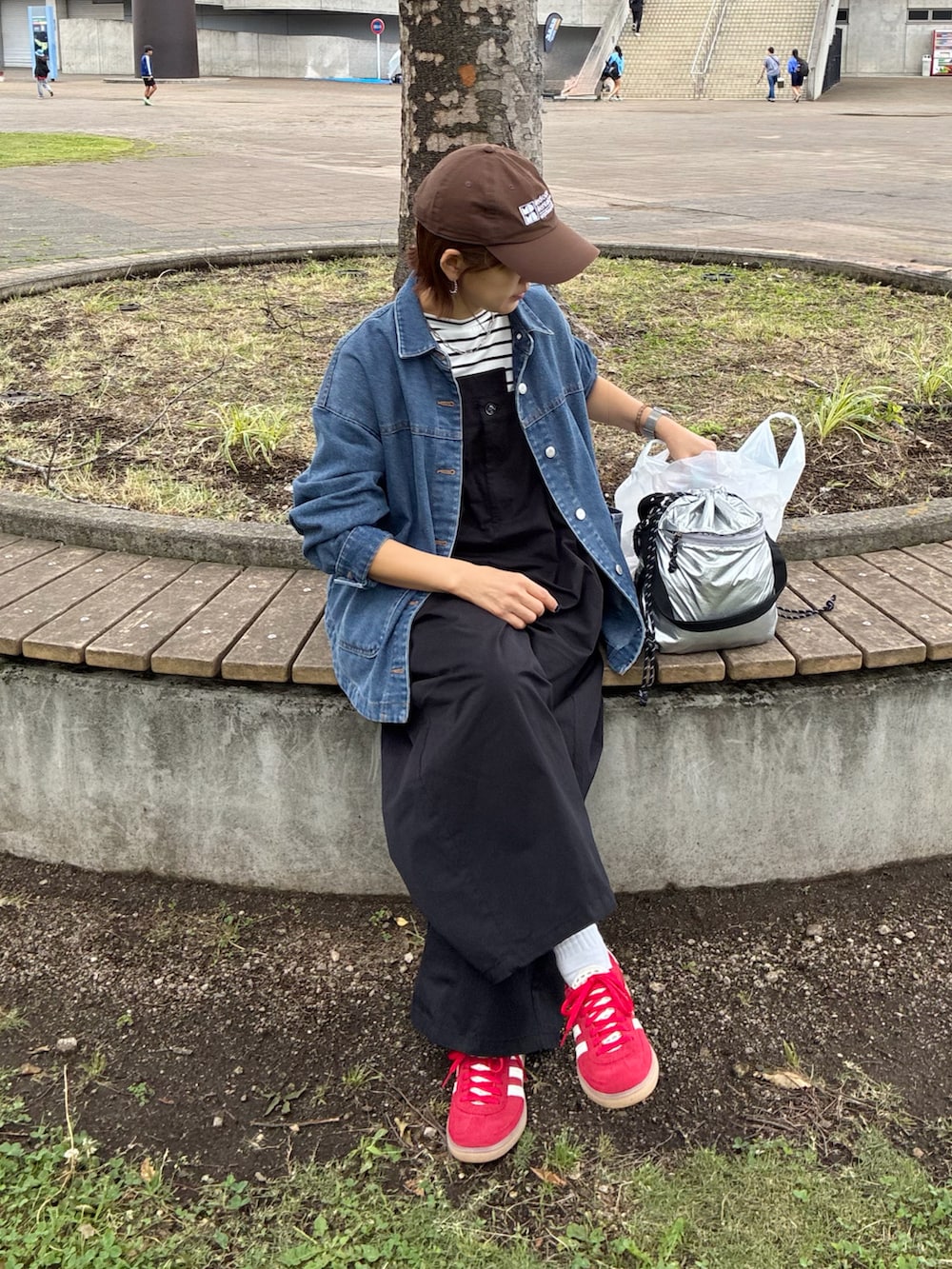 ブラック系のサロペット/オーバーオール、ホワイト系のTシャツ/カットソー、ブルー系のデニムジャケットを着用したレディースの夏コーディネートの3枚目の写真