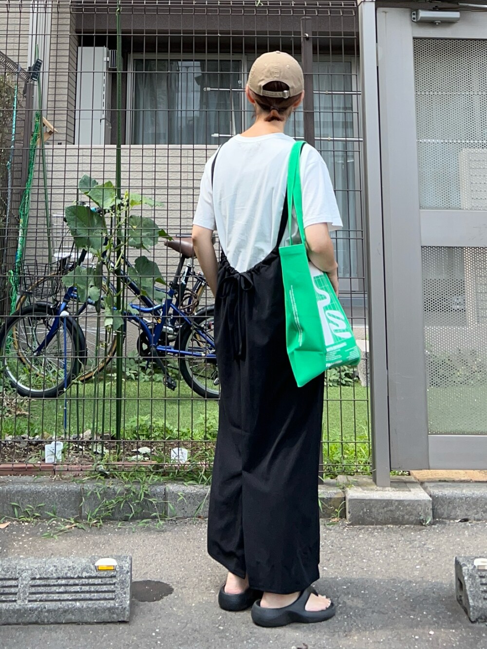 ホワイト系のTシャツ/カットソー、ブラック系のワンピース、グリーン系のバッグを着用したレディースの夏コーディネートの4枚目の写真