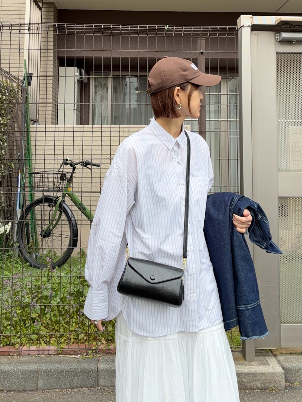 ホワイト系のスカート、ブルー系のデニムジャケット、ホワイト系のシャツ/ブラウスを着用したレディースの春コーディネートの4枚目の写真