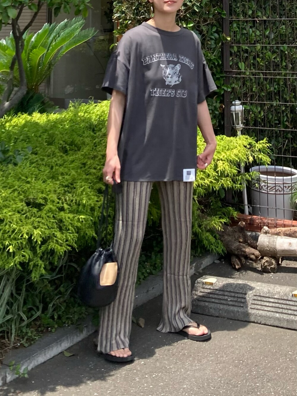 グレー系のTシャツ/カットソー、ベージュ系のその他パンツ、ブラック系のハンドバッグを着用したレディースの夏コーディネートの3枚目の写真