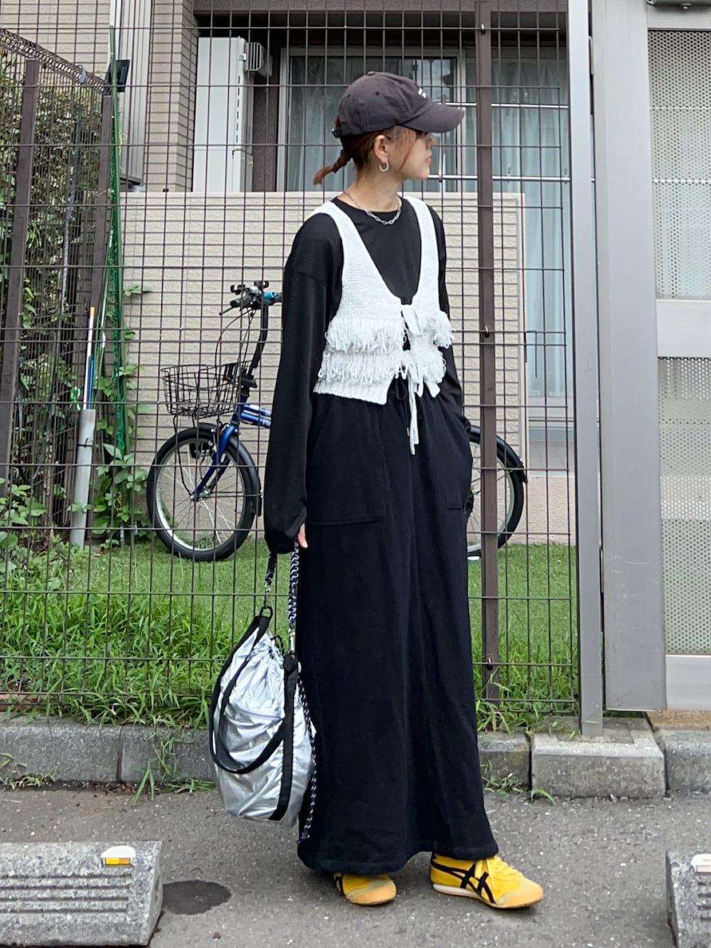 グレー系のベスト、ブラック系のTシャツ/カットソー、ブラック系のスカートを着用したレディースの秋コーディネートの2枚目の写真