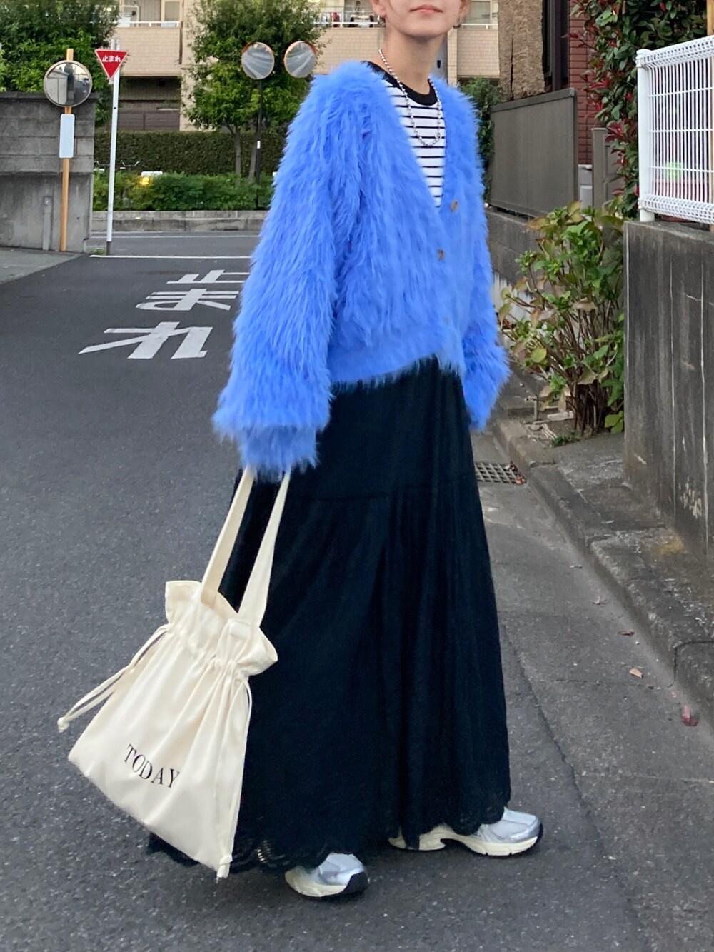 ブルー系のニット/セーター、ブラック系のTシャツ/カットソー、ブラック系のスカートを着用したレディースの秋コーディネートの5枚目の写真