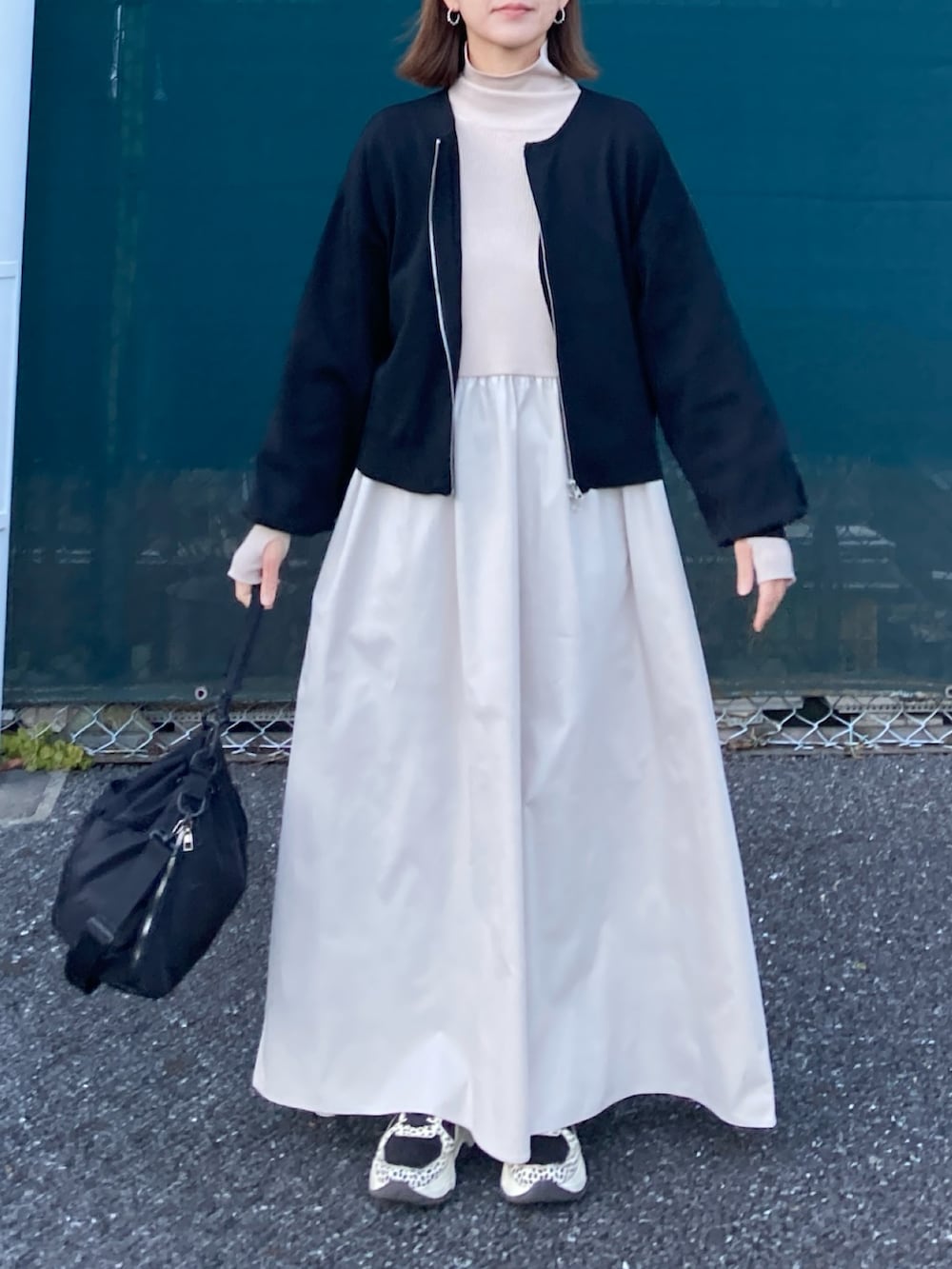 ブラック系のカーディガン/ボレロ、ベージュ系のワンピース、ブラック系のショルダーバッグを着用したレディースの冬コーディネートの2枚目の写真