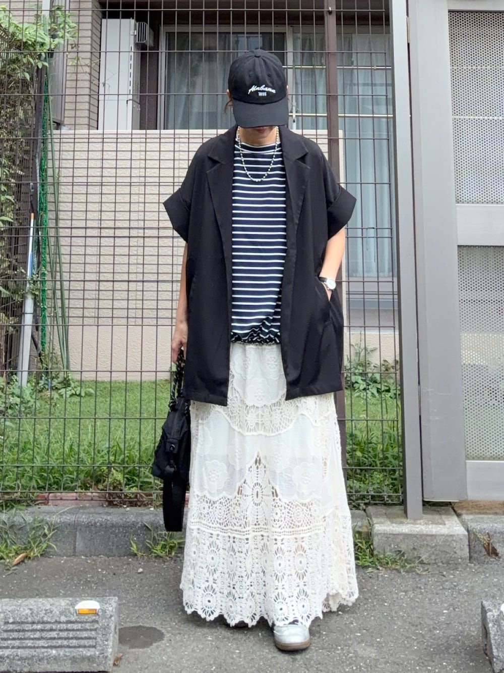 ブルー系のTシャツ/カットソー、ブラック系のテーラードジャケット、ホワイト系のスカートを着用したレディースの秋コーディネートの3枚目の写真