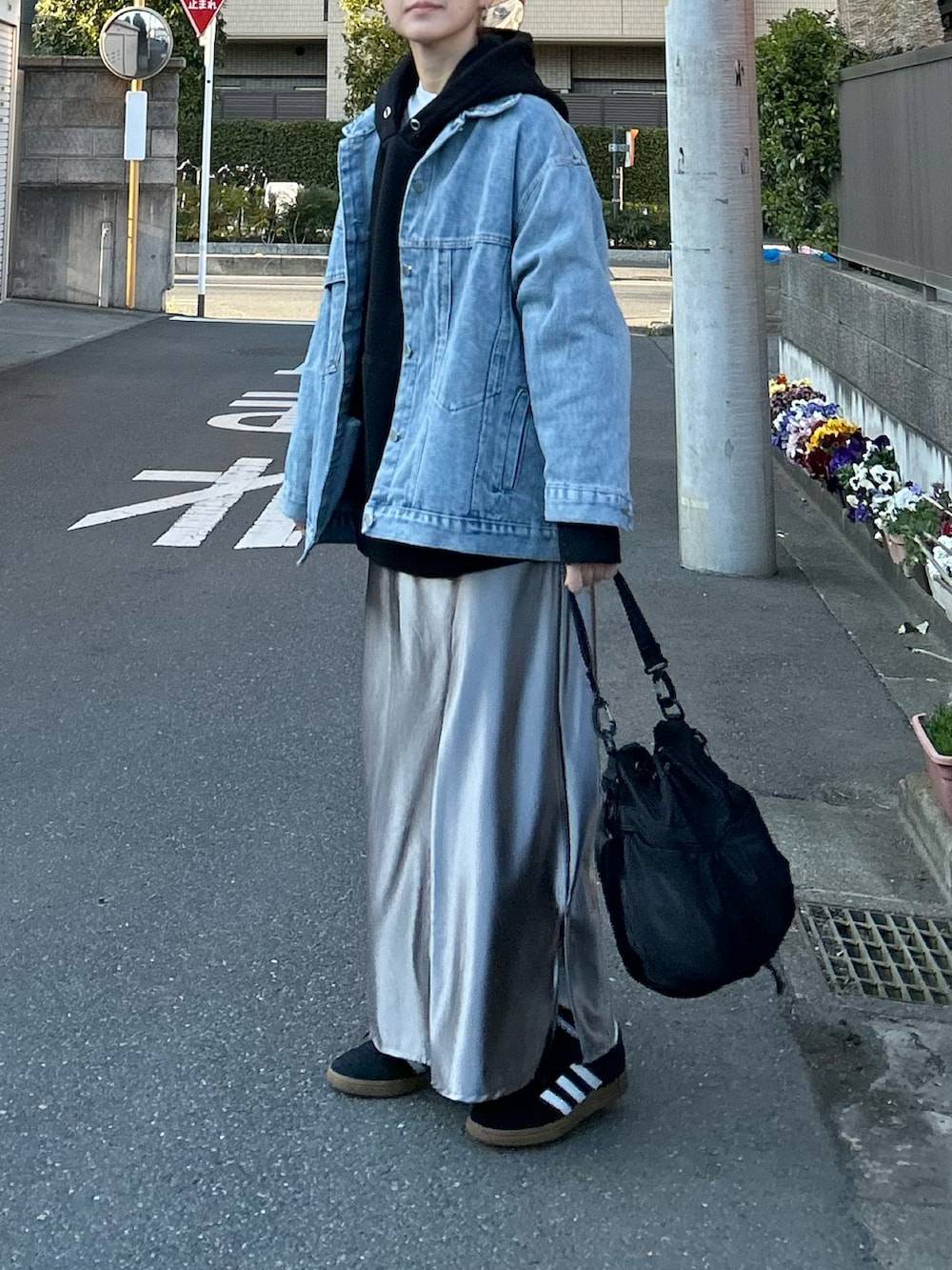 ブルー系のデニムジャケット、シルバー系のスカート、ブラック系のショルダーバッグを着用したレディースの春コーディネートの5枚目の写真