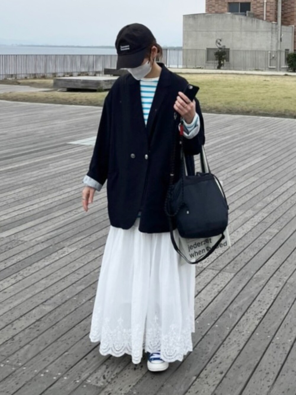 ブルー系のテーラードジャケット、ブルー系のTシャツ/カットソー、ホワイト系のスカートを着用したレディースの春コーディネートの2枚目の写真