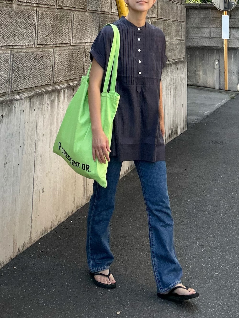 ブルー系のデニムパンツ、グレー系のシャツ/ブラウス、グリーン系のトートバッグを着用したレディースの夏コーディネートの2枚目の写真