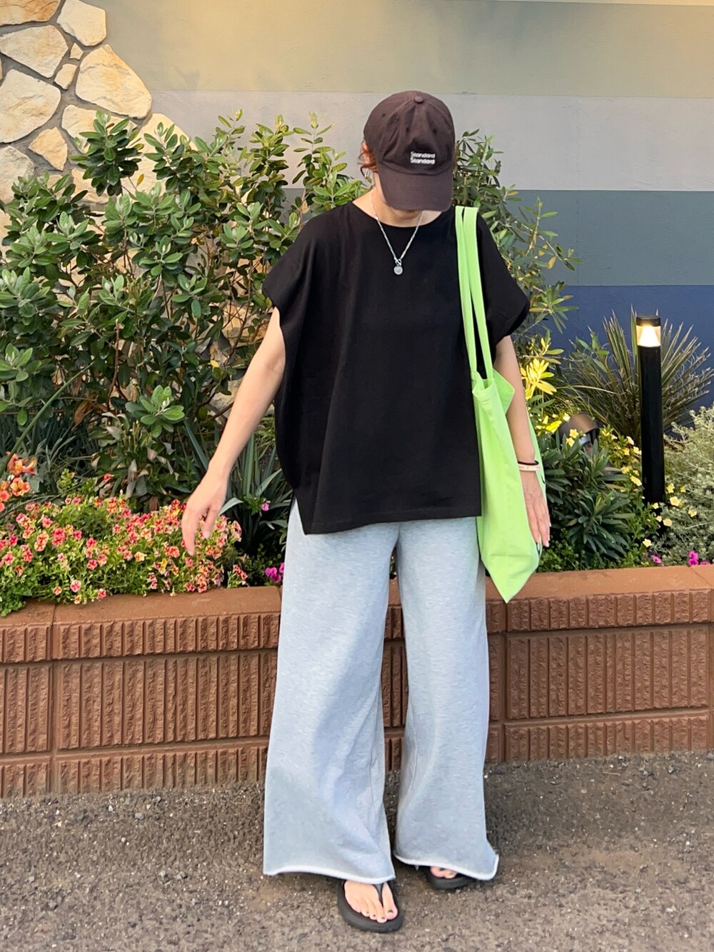 ブラック系のTシャツ/カットソー、グレー系のスウェットパンツ、グリーン系のトートバッグを着用したレディースの夏コーディネートの2枚目の写真