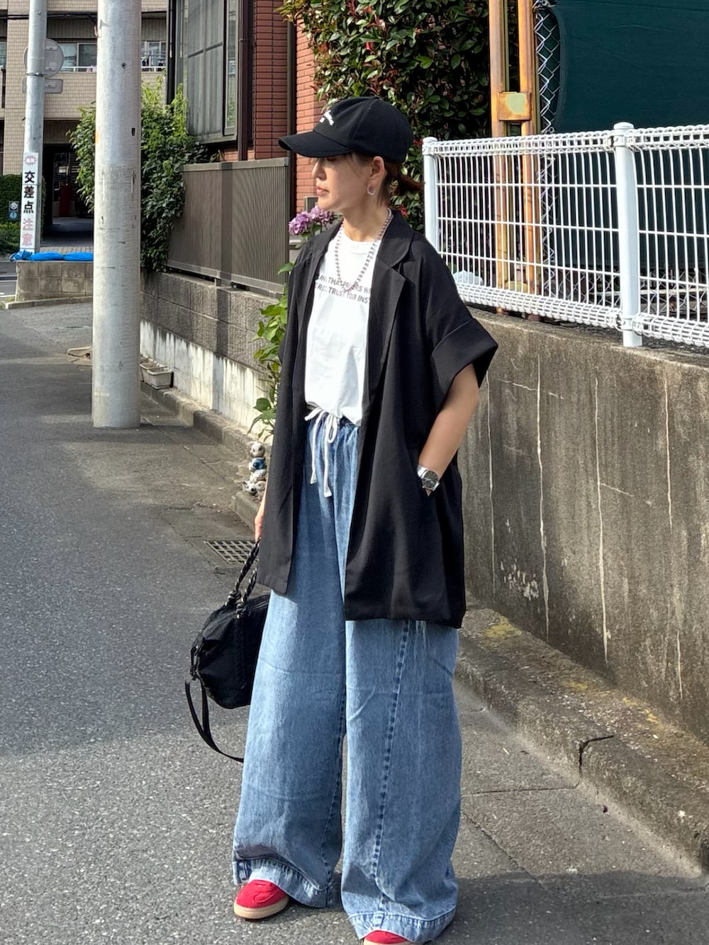 ブラック系のテーラードジャケット、ホワイト系のTシャツ/カットソー、ブラック系のトートバッグを着用したレディースの夏コーディネートの3枚目の写真