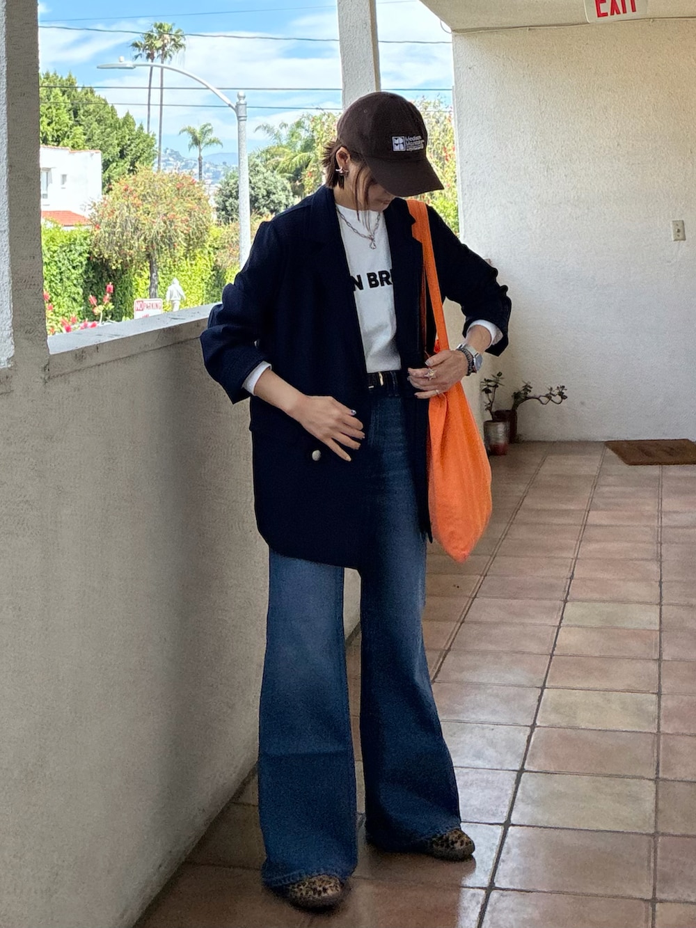 ブルー系のテーラードジャケット、ホワイト系のTシャツ/カットソー、ブラック系のスニーカーを着用したレディースの春コーディネートの3枚目の写真
