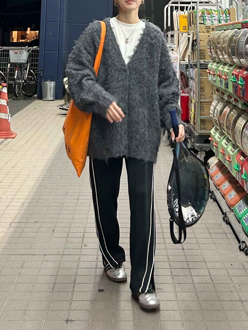 ブラック系のスウェットパンツ、オレンジ系のトートバッグ、グレー系のカーディガン/ボレロを着用したレディースの秋コーディネートの5枚目の写真