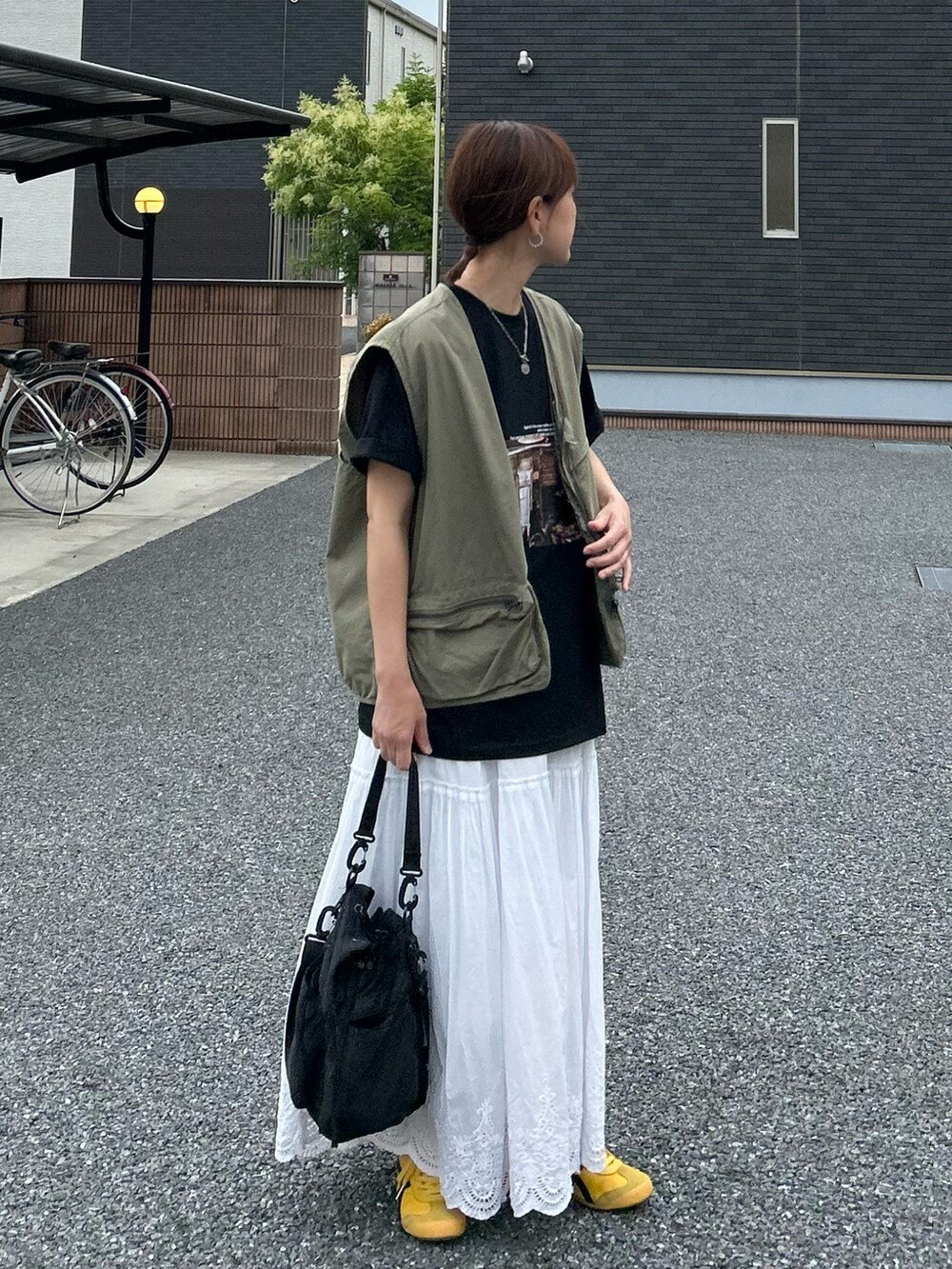 ブラック系のTシャツ/カットソー、ホワイト系のスカート、ブラック系のショルダーバッグを着用したレディースの夏コーディネートの4枚目の写真