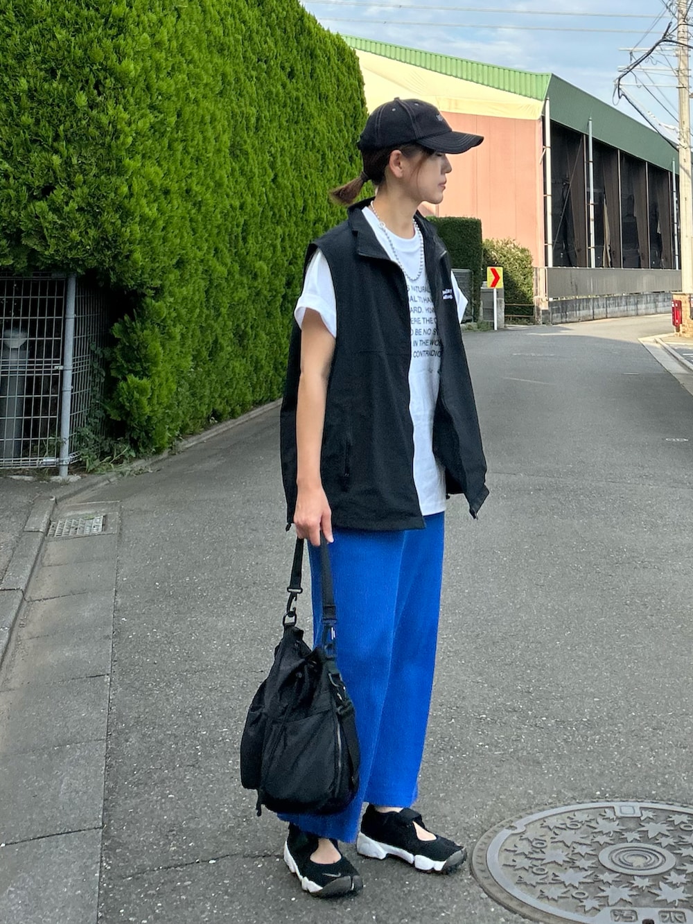 ホワイト系のTシャツ/カットソー、ブラック系のベスト、ブルー系のスカートを着用したレディースの夏コーディネートの5枚目の写真