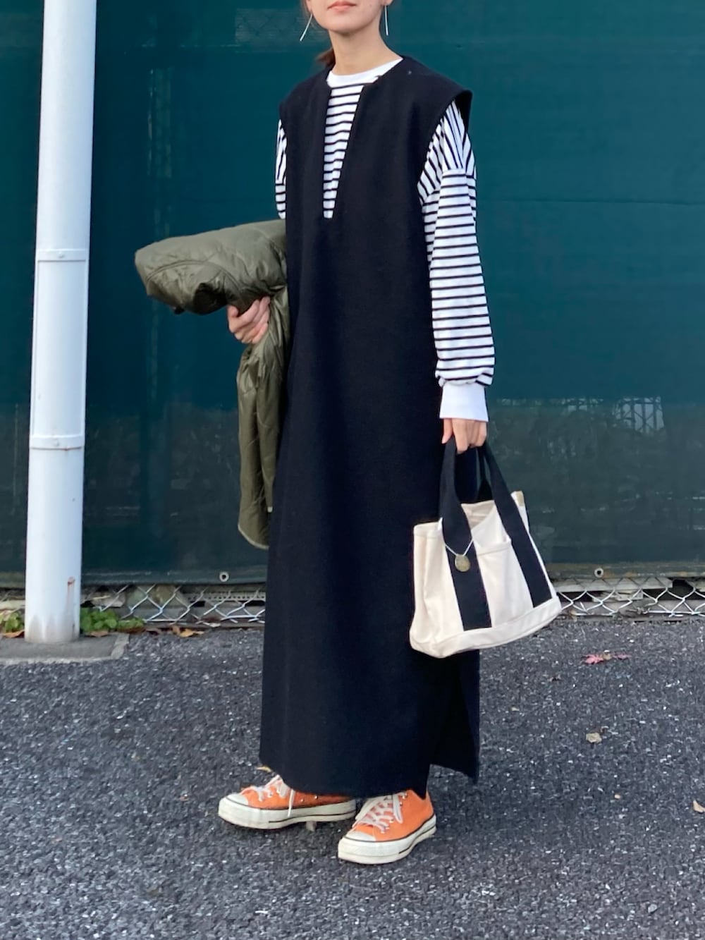 グリーン系のノーカラージャケット、ブラック系のワンピース、ブラック系のTシャツ/カットソーを着用したレディースの冬コーディネートの3枚目の写真