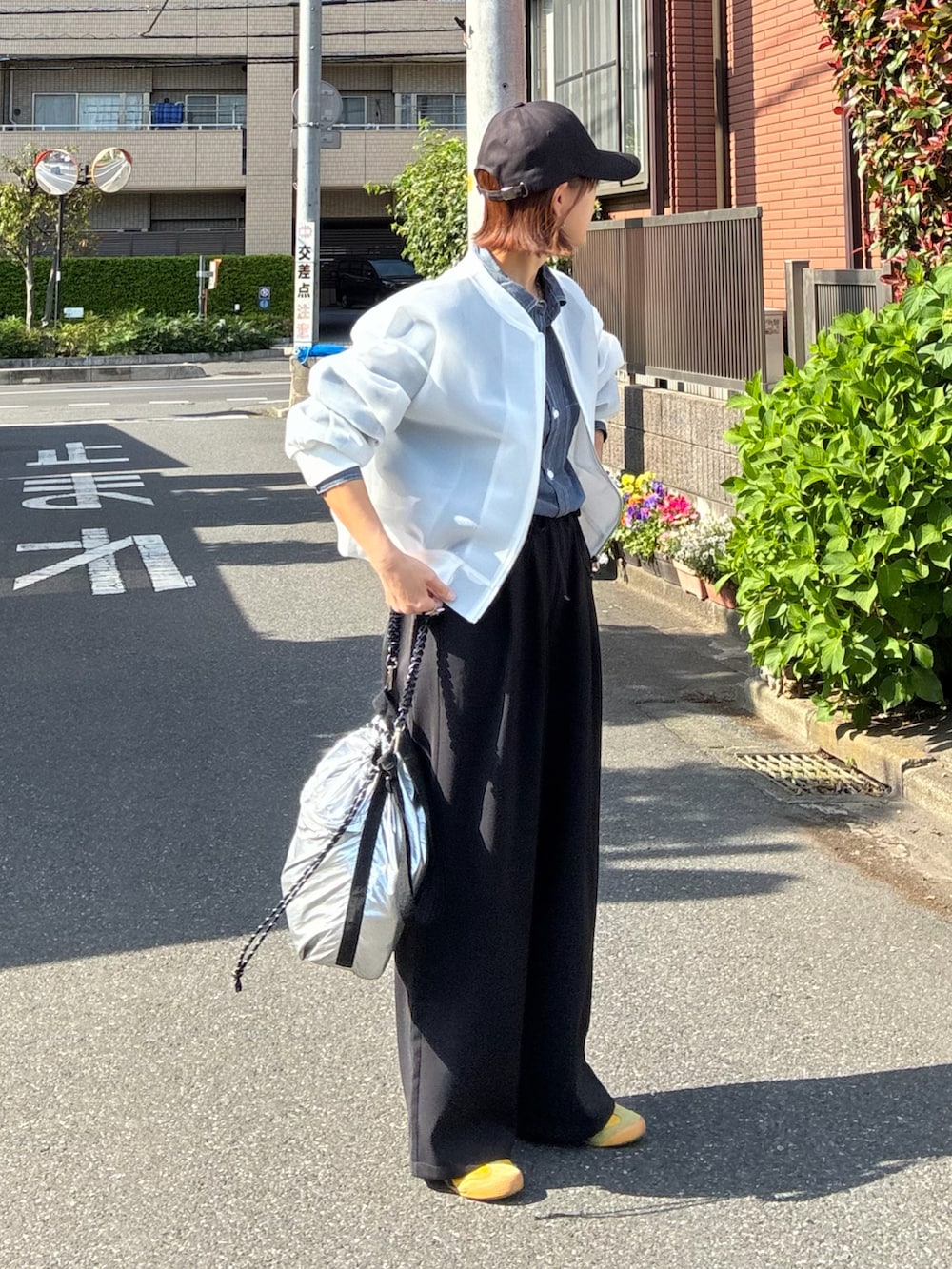 ブルー系のシャツ/ブラウス、ホワイト系のブルゾン、ブラック系のスラックスを着用したレディースの春コーディネートの4枚目の写真