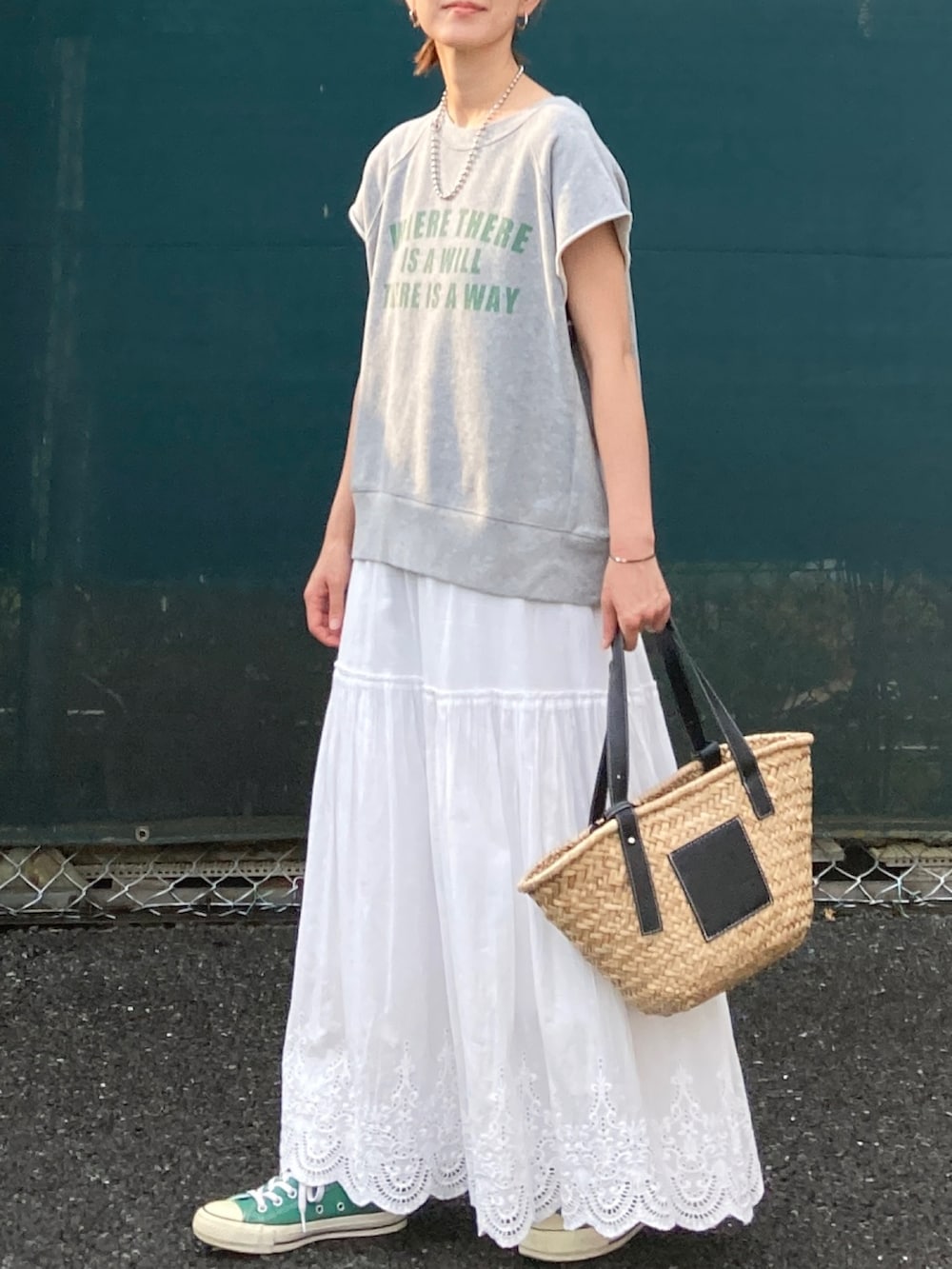 グレー系のTシャツ/カットソー、ホワイト系のスカート、ブラック系のかごバッグを着用したレディースの夏コーディネートの3枚目の写真