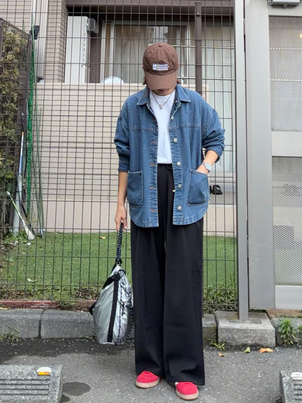 ホワイト系のTシャツ/カットソー、ブラック系のスラックス、シルバー系のショルダーバッグを着用したレディースの夏コーディネートの2枚目の写真