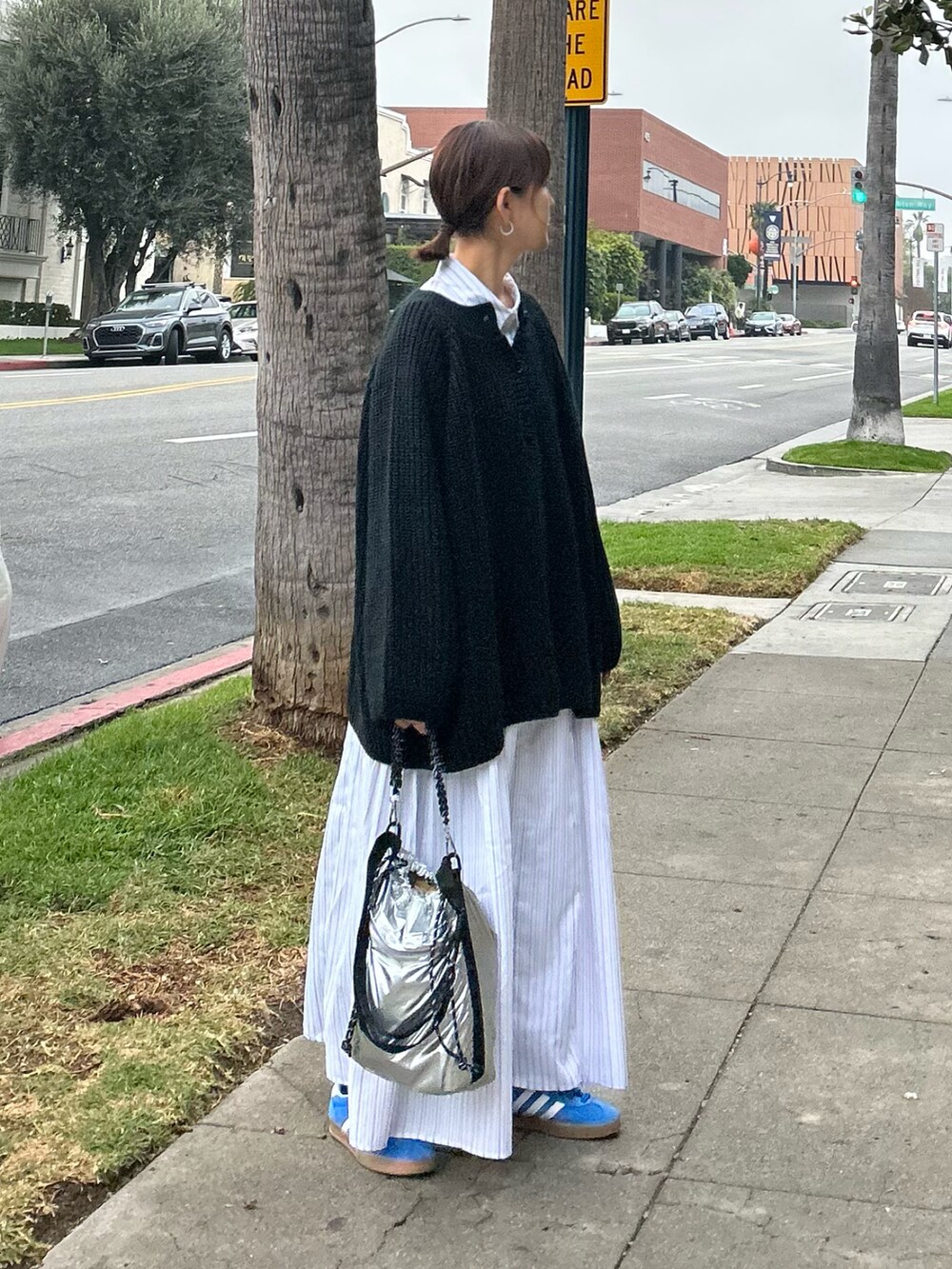 ブラック系のニット/セーター、ホワイト系のシャツワンピース、シルバー系のトートバッグを着用したレディースの冬コーディネートの5枚目の写真