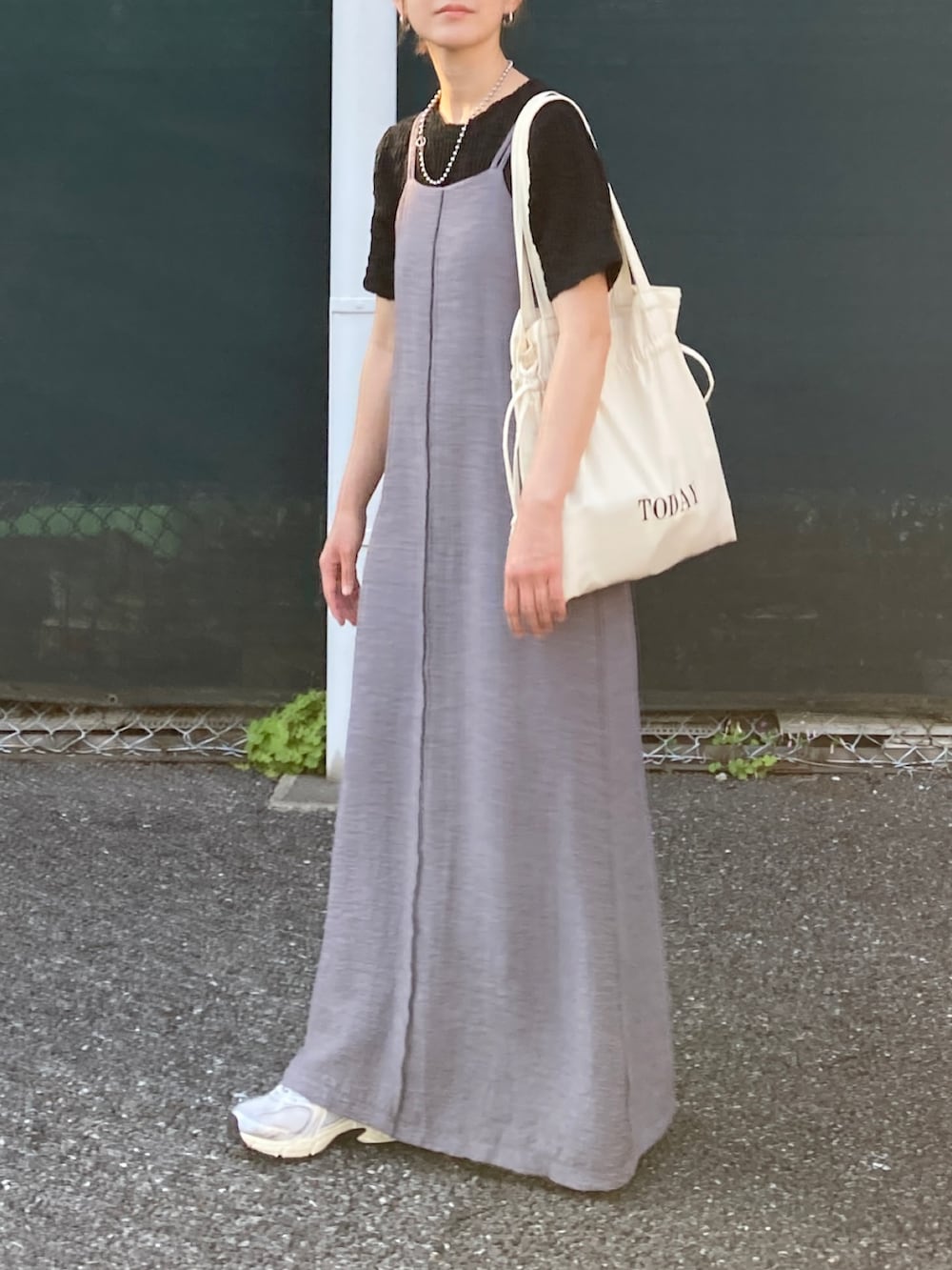ブラック系のTシャツ/カットソー、グレー系のワンピース、ホワイト系のトートバッグを着用したレディースの春コーディネートの2枚目の写真