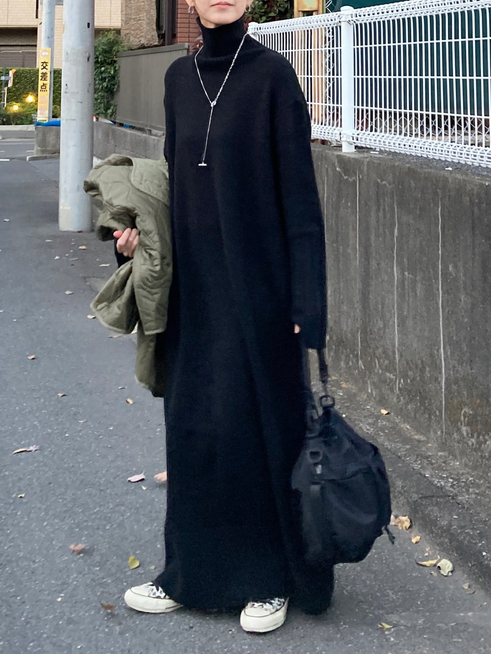 ブラック系のワンピース、ブラック系のショルダーバッグ、その他のスニーカーを着用したレディースの冬コーディネートの4枚目の写真