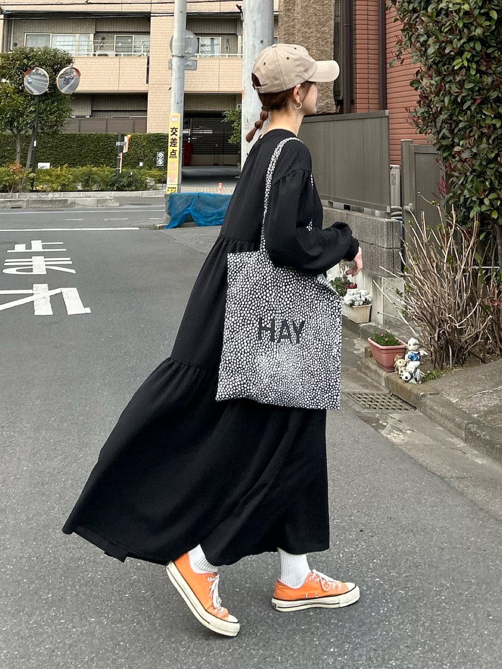 ブラック系のシャツワンピース、ブラック系のトートバッグ、ベージュ系のキャップを着用したレディースの春コーディネートの3枚目の写真
