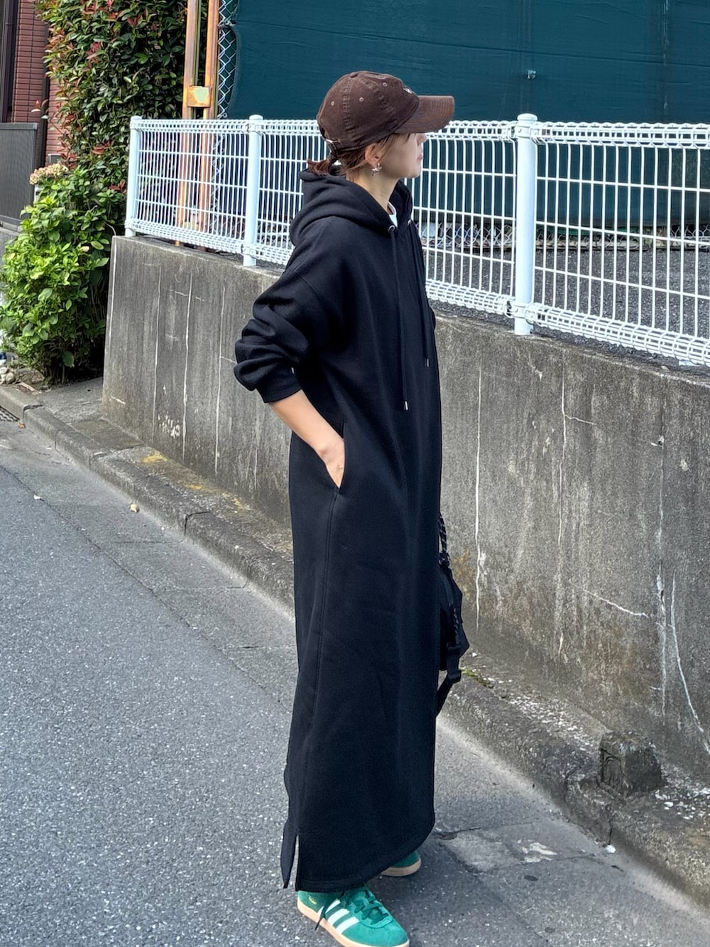 ブラック系のワンピース、ブラック系のトートバッグ、グリーン系のスニーカーを着用したレディースの夏コーディネートの4枚目の写真