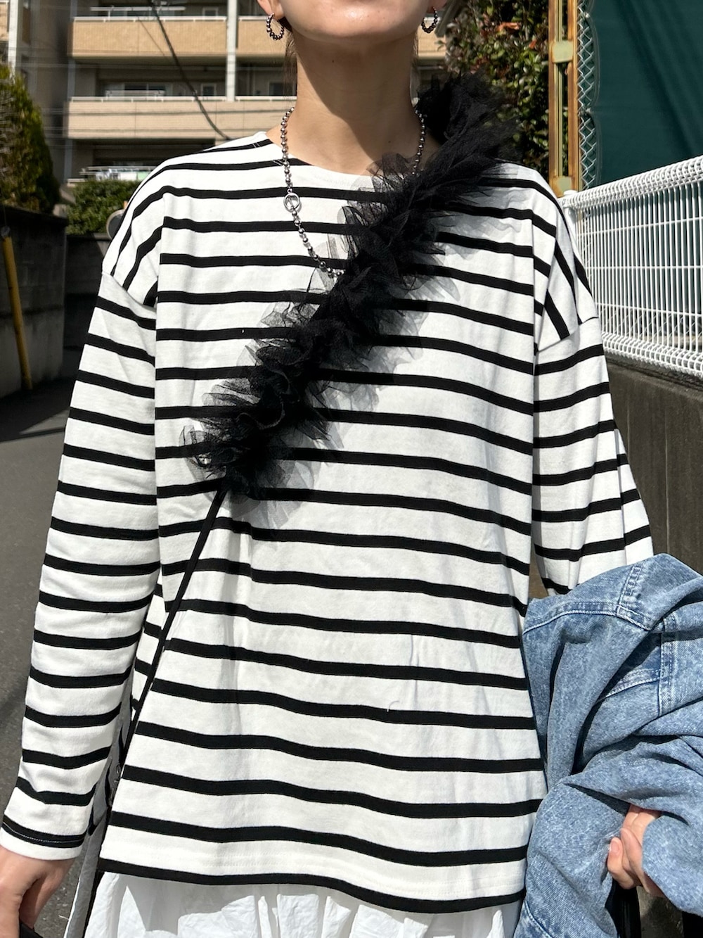 ホワイト系のTシャツ/カットソー、ホワイト系のスカート、ブラック系のショルダーバッグを着用したレディースの春コーディネートの3枚目の写真