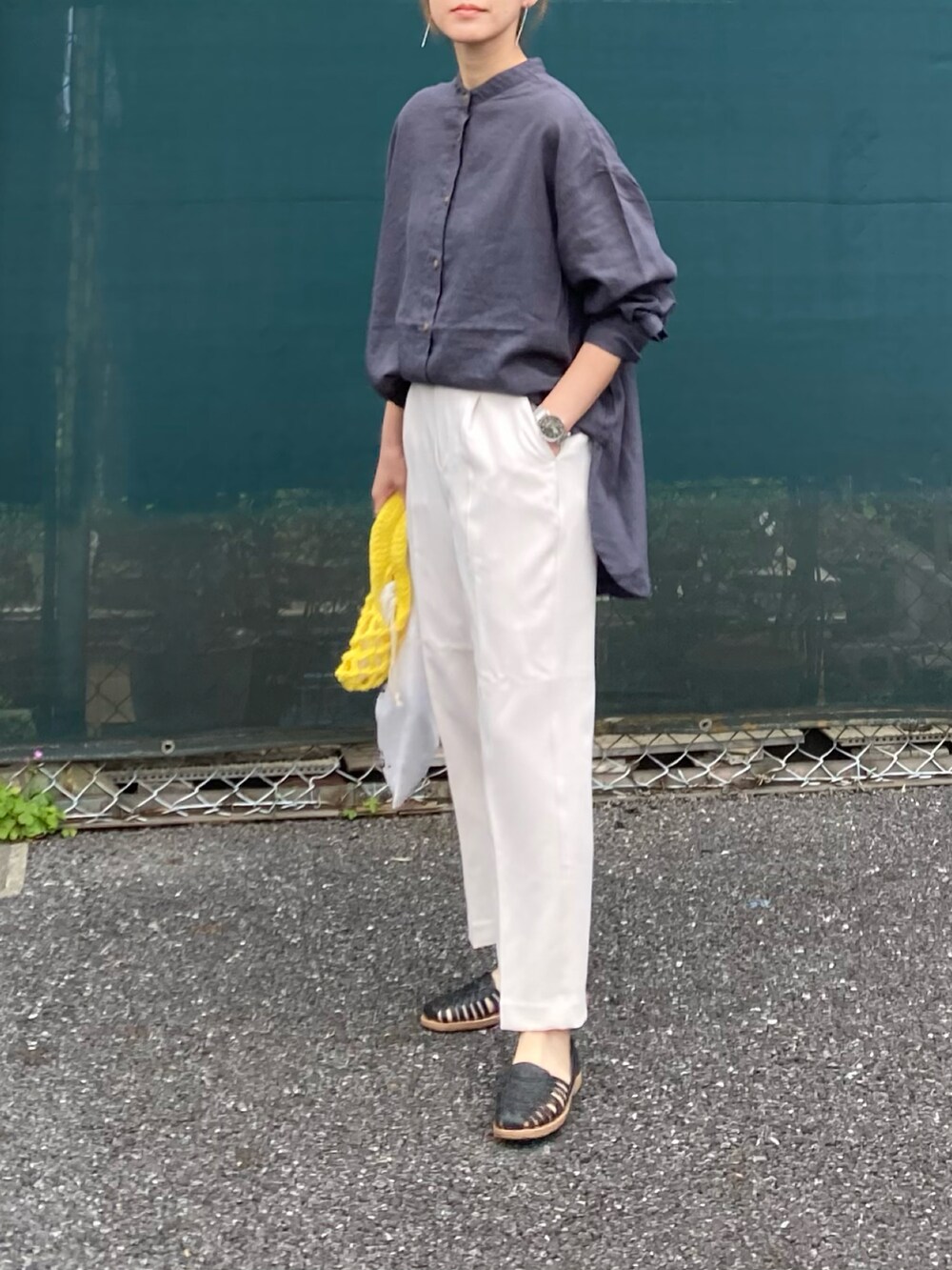 グレー系のシャツ/ブラウス、ホワイト系のスラックス、イエロー系のハンドバッグを着用したレディースの春コーディネートの2枚目の写真