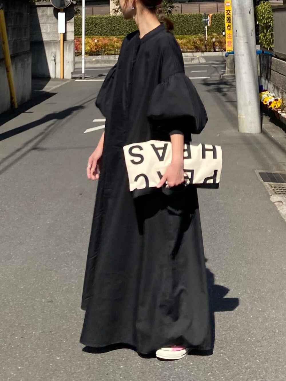 ブラック系のワンピース、ホワイト系のトートバッグ、レッド系のスニーカーを着用したレディースの春コーディネートの2枚目の写真