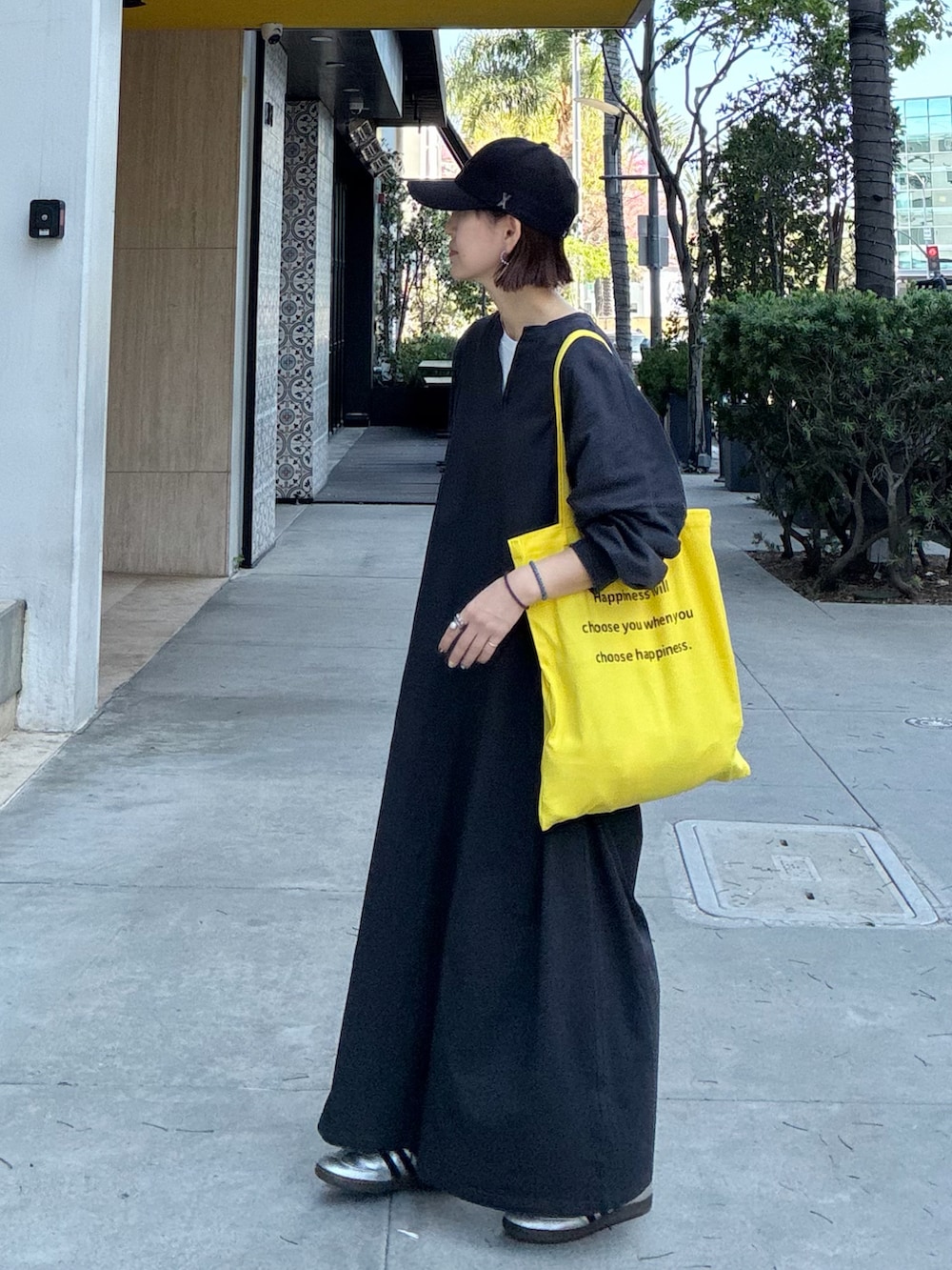 グレー系のワンピース、イエロー系のトートバッグ、シルバー系のスニーカーを着用したレディースの春コーディネートの5枚目の写真
