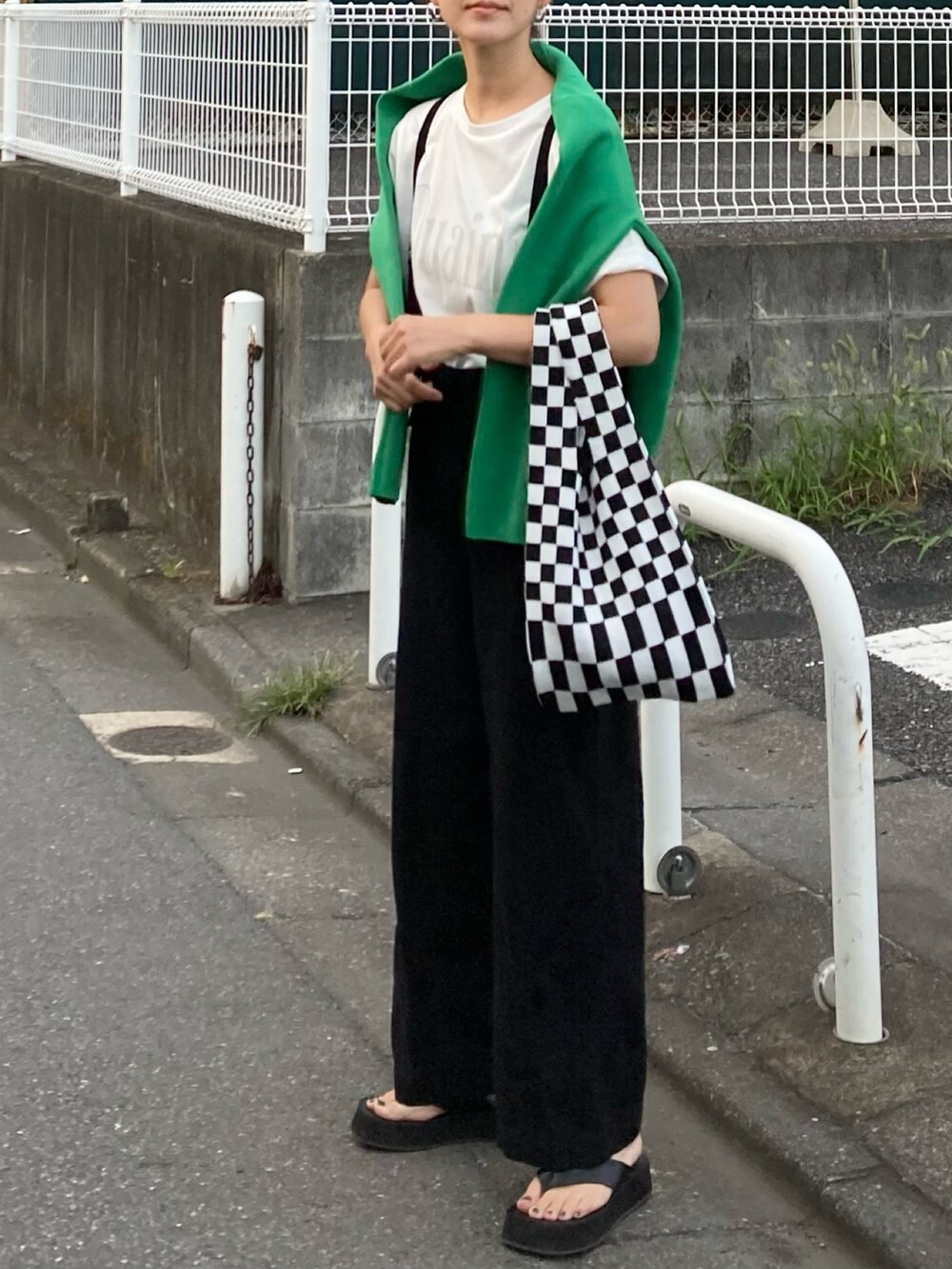 ホワイト系のTシャツ/カットソー、ブラック系のサロペット/オーバーオール、ブラック系のサンダルを着用したレディースの夏コーディネートの2枚目の写真