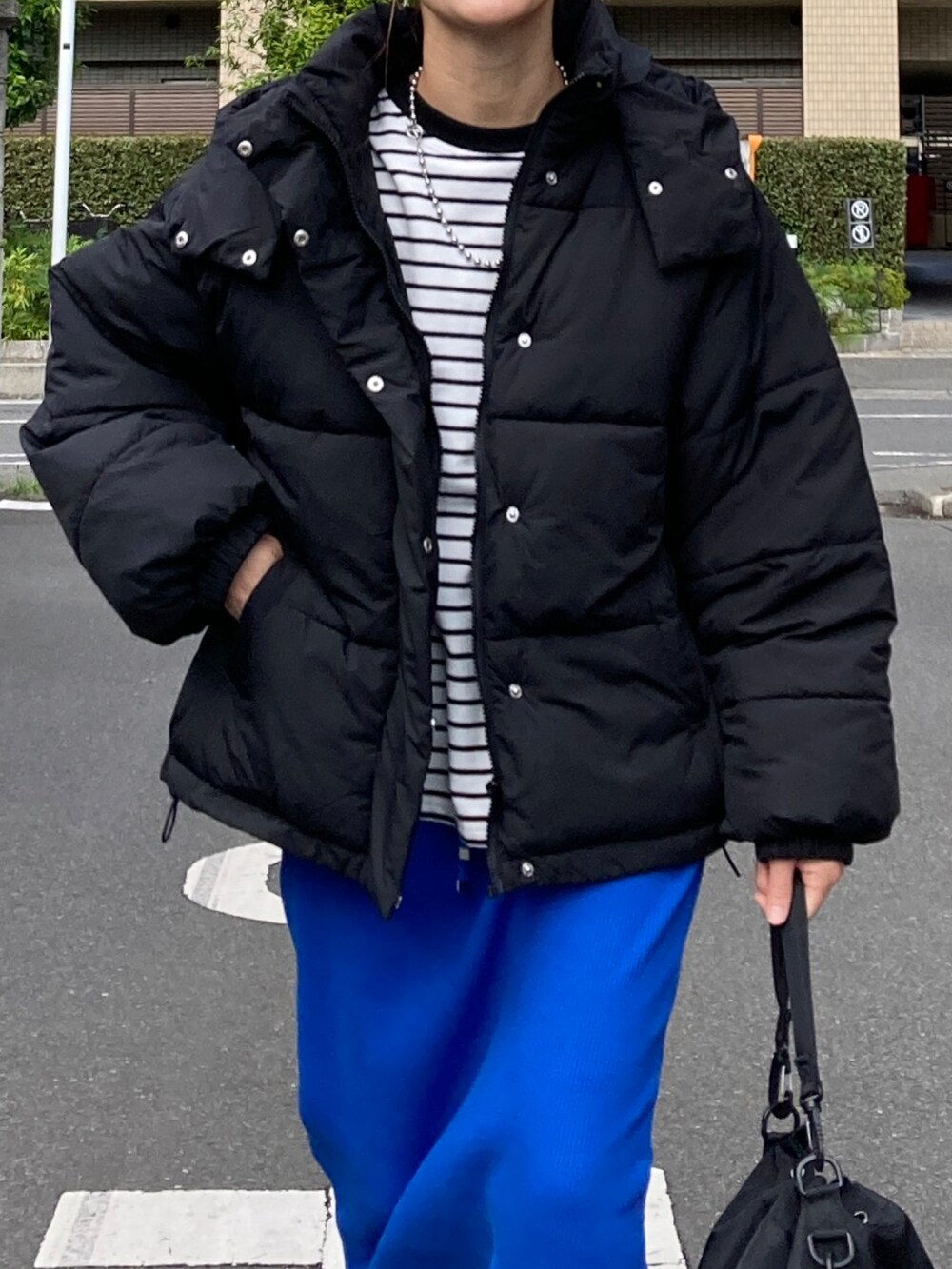 ブラック系のダウンジャケット/コート、ブラック系のTシャツ/カットソー、ブルー系のスカートを着用したレディースの秋コーディネートの5枚目の写真