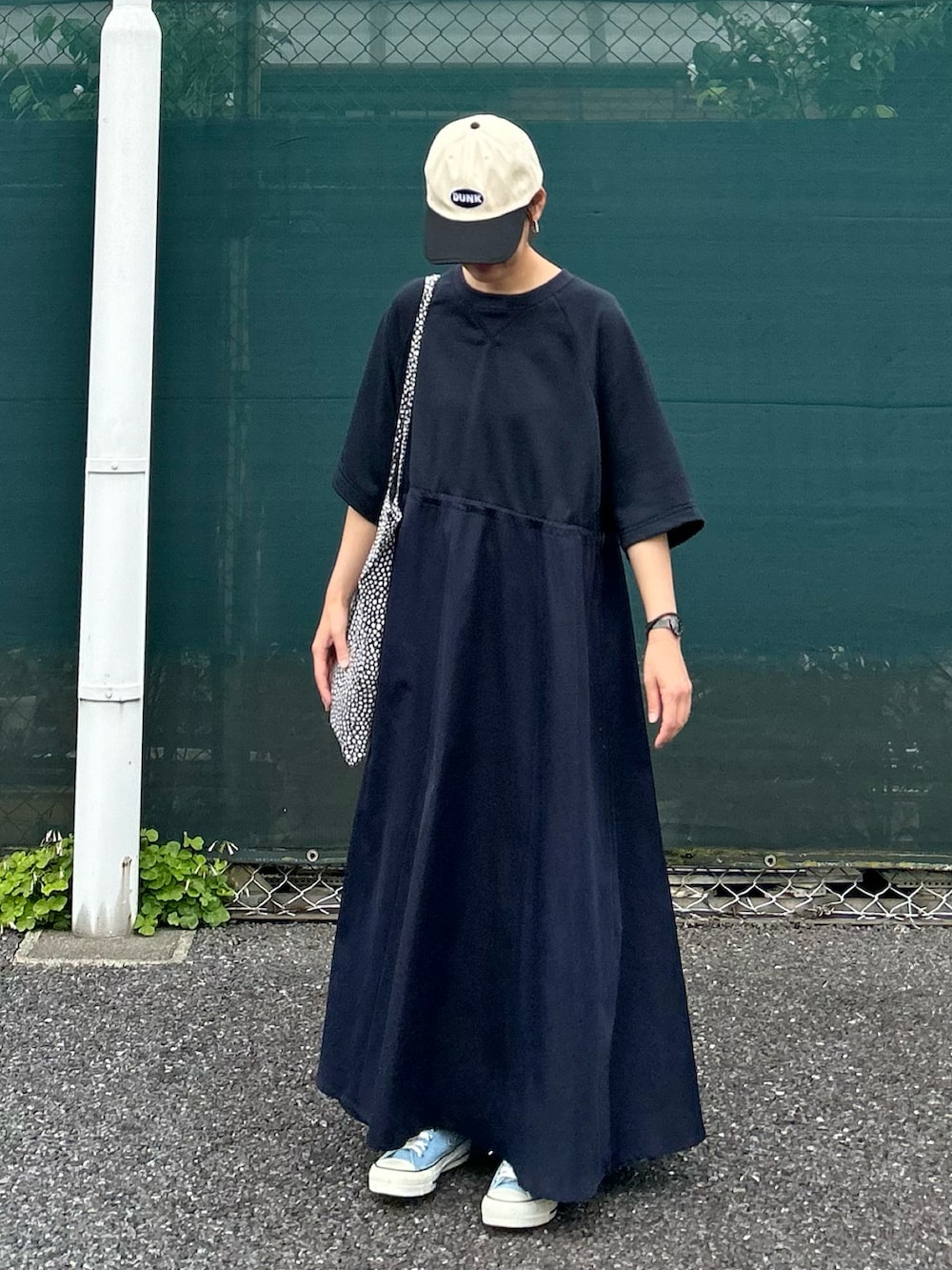 ブルー系のワンピース、ブラック系のトートバッグ、ブルー系のスニーカーを着用したレディースの夏コーディネートの4枚目の写真