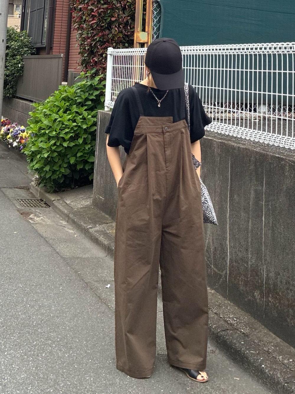 ブラック系のTシャツ/カットソー、ブラウン系のサロペット/オーバーオール、ブラック系のキャップを着用したレディースの春コーディネートの3枚目の写真