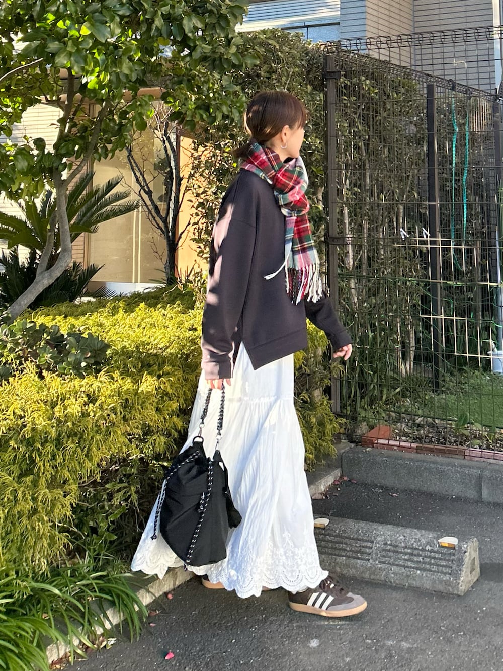 グレー系のTシャツ/カットソー、ホワイト系のスカート、ブラック系のトートバッグを着用したレディースの冬コーディネートの3枚目の写真